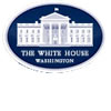 An oval emblem featuring a white illustration of the White House on a blue background, with the words The White House Washington written below the building.